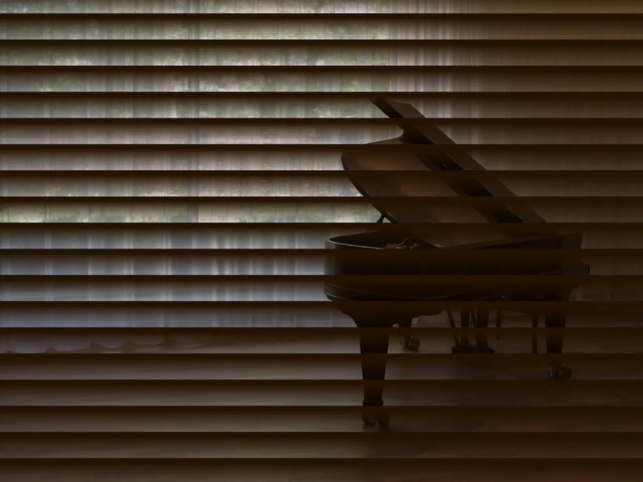 In the foreground of the image there is a window blind. Through which we can see a musical...