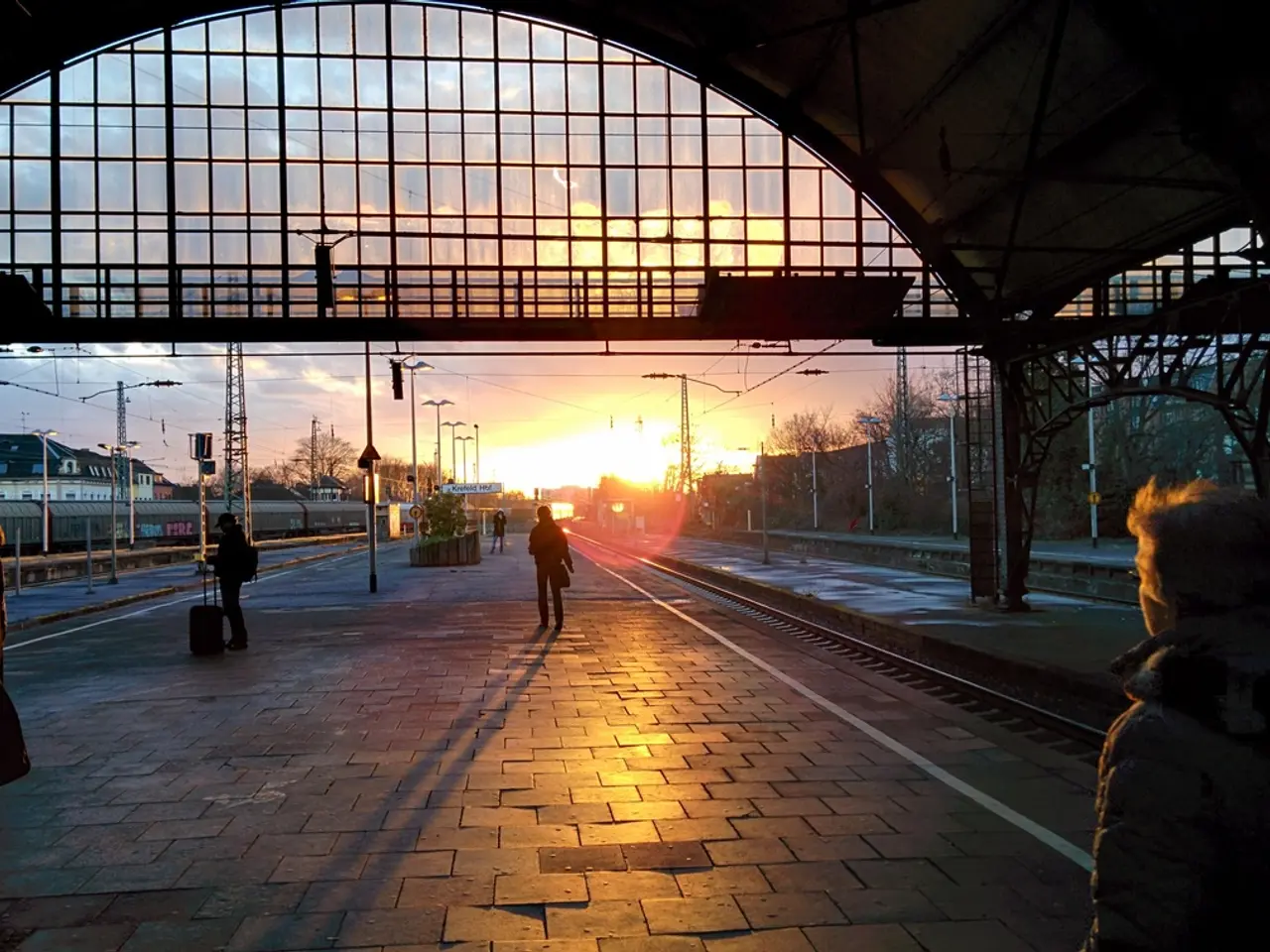In the picture it looks like a railway station, there are few people standing on the platform and...