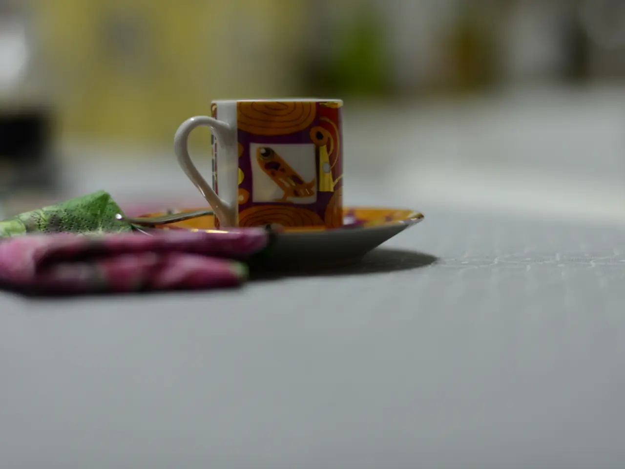 In this image we can see cup, saucer, spoon and napkin.