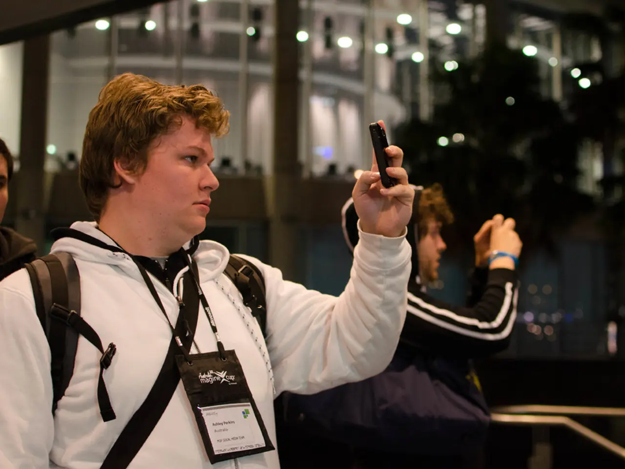 In this picture we can see people standing and taking pictures of something in their mobiles.