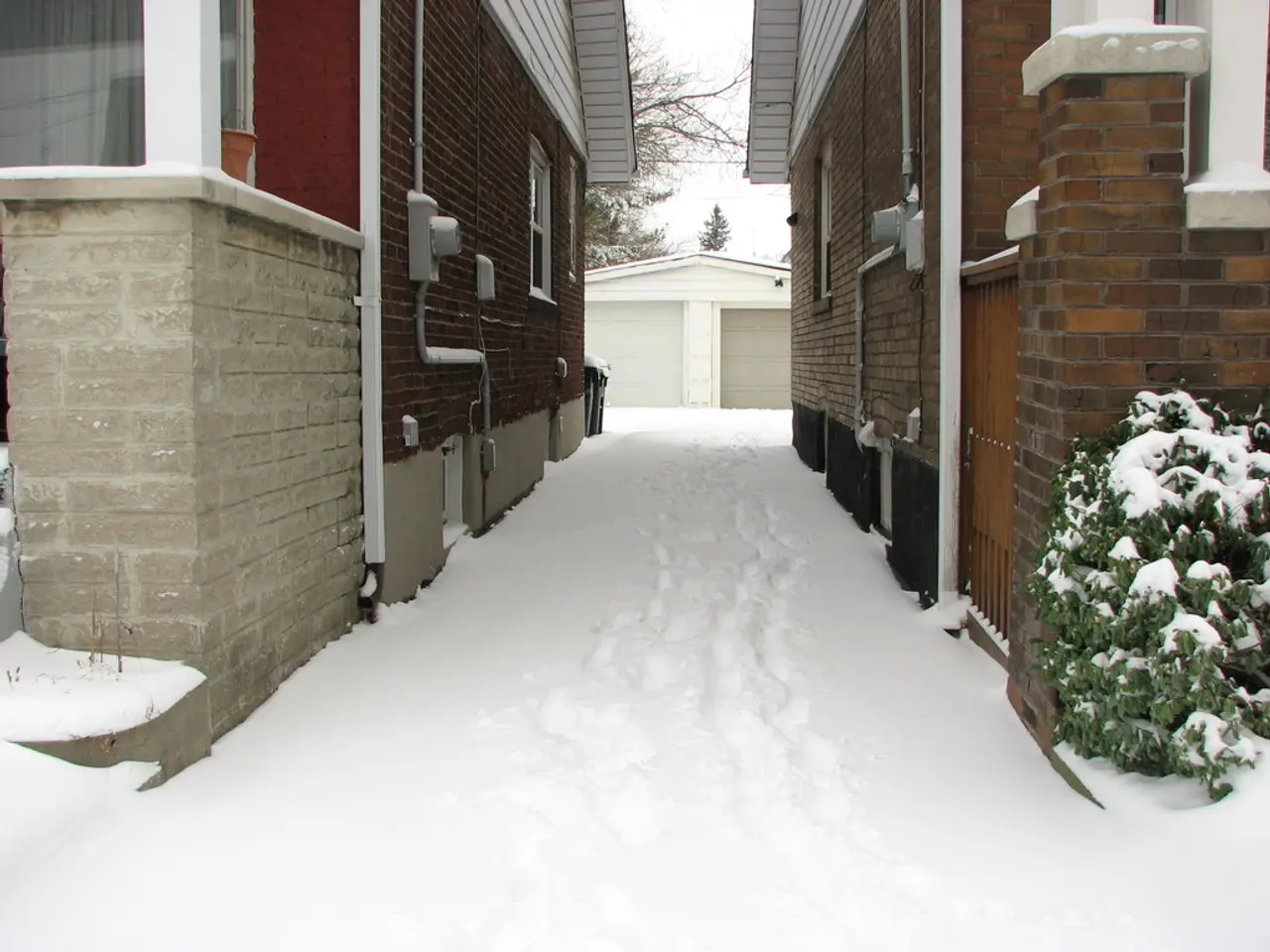 In the picture there are two houses and the land around the house is completely covered with snow...