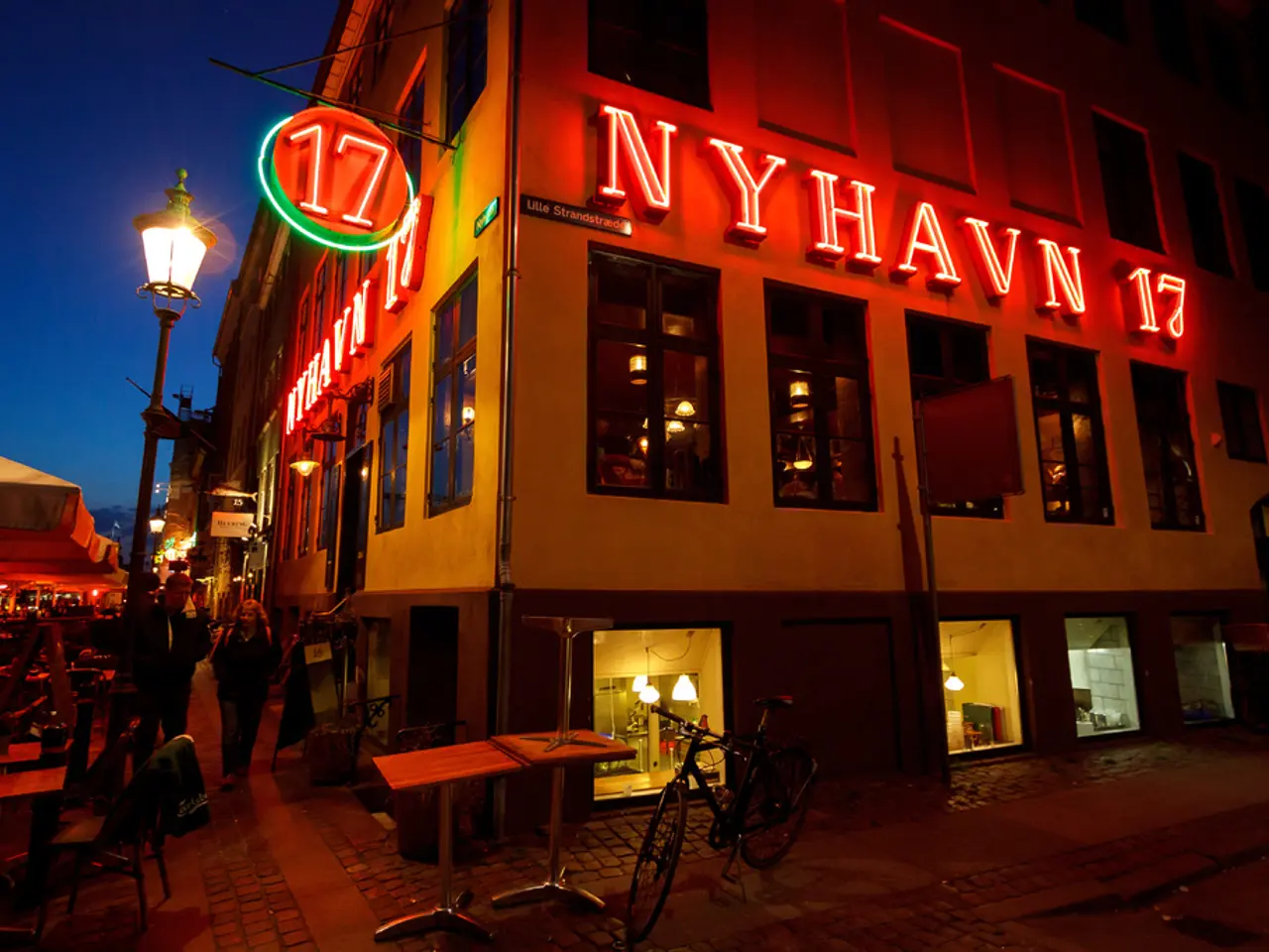 The building has something written on it which is red is color and there is also a bicycle and some...