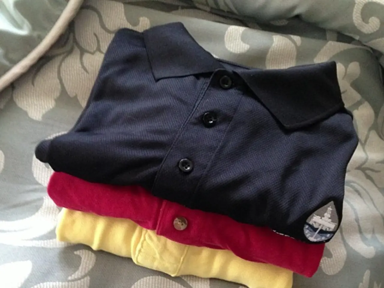 In this picture I can see polo t-shirts and I can see cloth in the background.