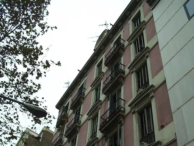 In this picture we can see buildings with many balcony windows and lights. Here we can see green...