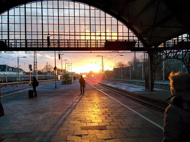 In the picture it looks like a railway station, there are few people standing on the platform and...