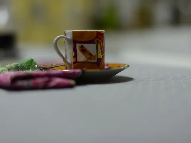 In this image we can see cup, saucer, spoon and napkin.