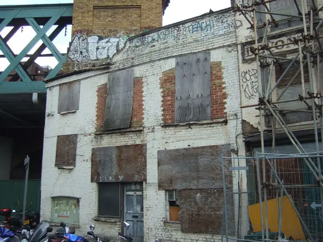 In this picture, it seems like a house structure in the center and there are vehicles at the bottom...