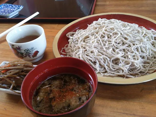 In the image we can see there is a bowl in which there is a curry and in a plate there are noodles...