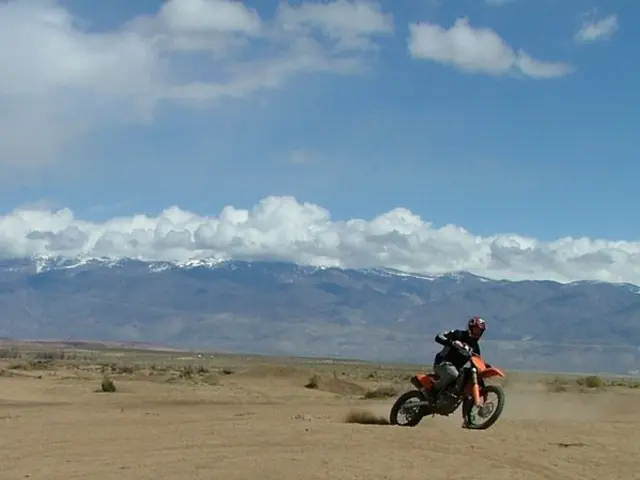 As we can see in the image there is grass, current polls, a man riding motor cycle,s hills, sky and...