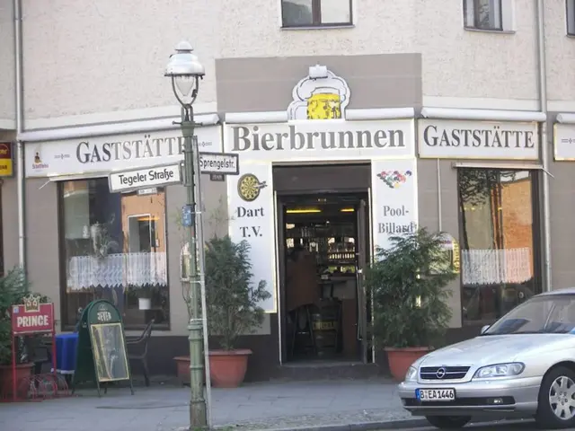 In the image there is a car on road on right side and behind there is a building with plants on...