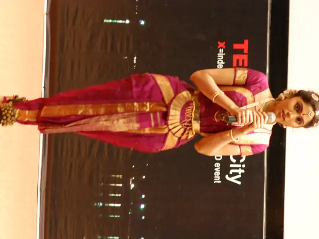 This is the woman standing and holding a mike. She wore a fancy dress and jewellery. In the...