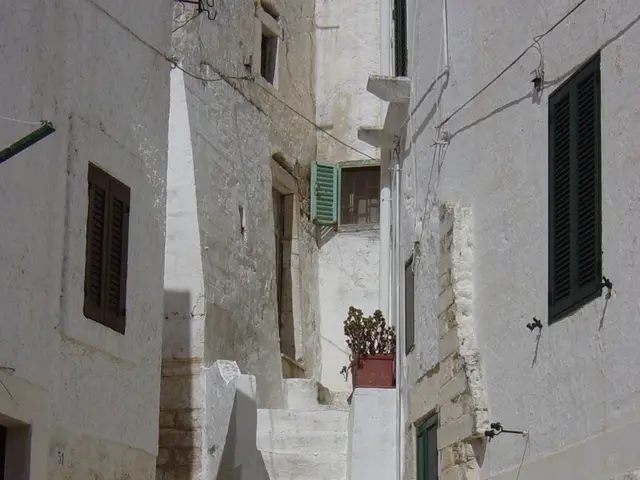 In the image there are many buildings and in front of the middle building there are stairs.