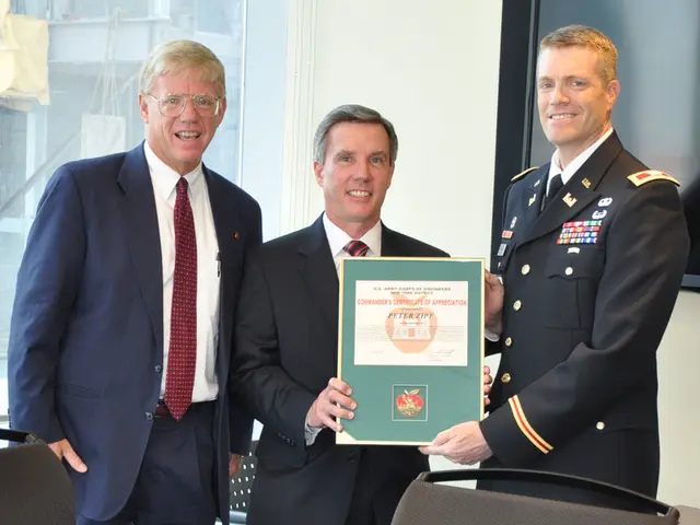 Here there are three men standing and the right side two men are holding a framed certificate with...