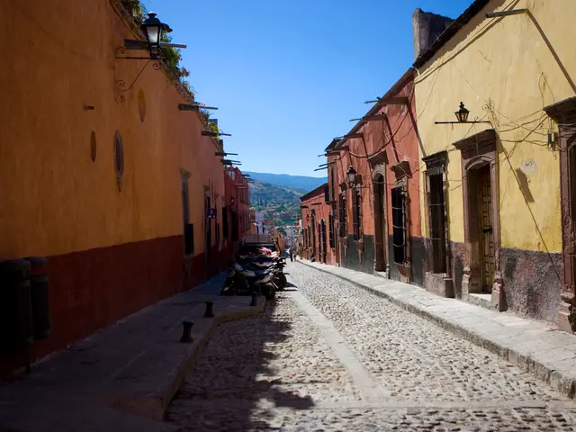 In this image there is a empty road where so many bikes are parked, beside that there are so many...