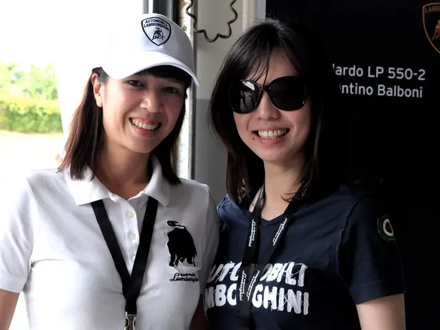 In the picture we can see two women are standing beside each other and they are smiling and one...